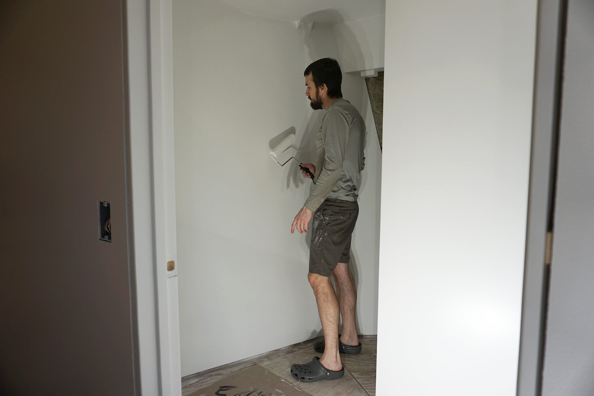Applying paint with a roller to the bathroom walls.