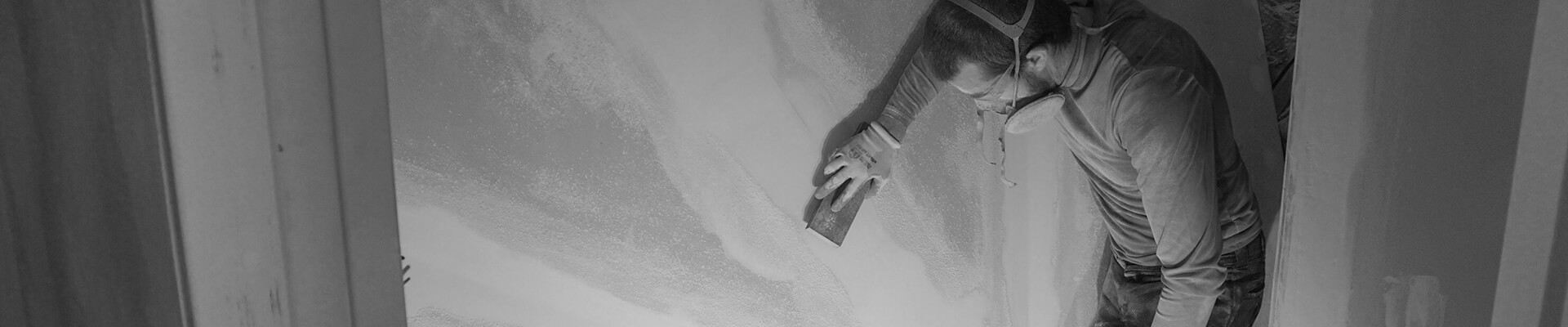 A close-up view of the drywall being finished in the Mini Dome in black and white.