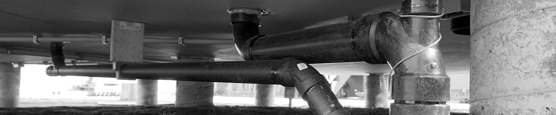 A close-up view of the pipes and conduit under the floor of the Mini Dome.